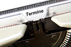 Schreibmaschine, die "Termine" auf ein weißes Blatt Papier tippt